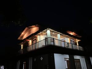 a white house with a balcony at night at Cashew Garden Resort & Restaurant in Dambulla +42 photos