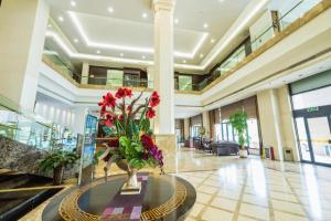 a lobby with a vase of flowers on a table at Qingdao Royal Garden Hotel in Jimo