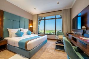 a bedroom with a bed and a desk and a computer at Madareem Hotel in Riyadh