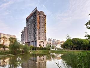 HexiaにあるGreenTree Eastern Hotel Huai'an Bus Station Zhou Enlai Memorialの川の横の高層建築物
