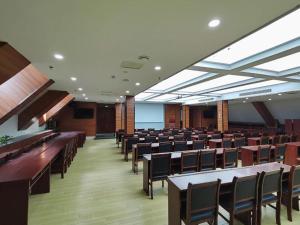 une chambre avec des rangées de tables et de chaises dans l'établissement GreenTree Inn Luoyang Train Station Zhuangyuanhong Road Hotel, à Luoyang