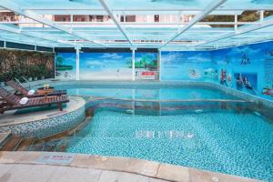 a large swimming pool in a building at Xinyuan Hot Spring Hotel in Haikou