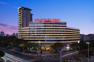a large building with a sign on top of it at Leisure Hotel in Dongguan