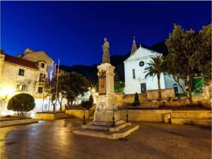 a statue in a square in front of a building at Apartments Kata - Studio Apartment in Makarska +6 photos