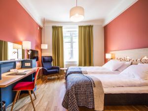 a hotel room with a bed and a desk at Hotell Bondeheimen in Oslo
