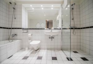 a bathroom with a sink and a toilet and a shower at Hotell Bondeheimen in Oslo