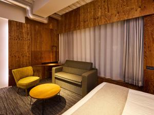 a bedroom with a bed and a chair and a desk at ONE@Tokyo in Tokyo