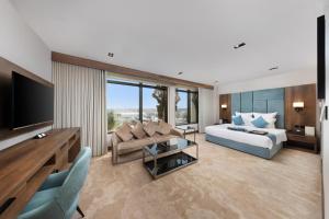 a living room with a king sized bed and a television at Madareem Hotel in Riyadh