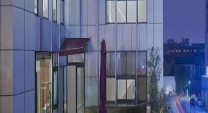 a tall glass building with a red object in front of it at Changshu Please Hotel in Changshu