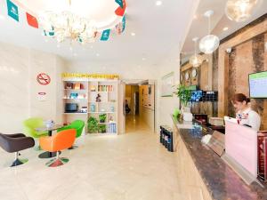 a woman standing at a counter in a store at GreenTree Inn Shanghai Guangxin Road Tongji Hospital Express Hotel in Shanghai