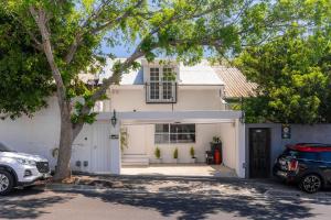 a white house with a car parked in front of it at Modern Rustic Gem at the foot of Table Mountain in Cape Town