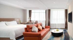 une chambre d'hôtel avec un lit et un canapé dans l'établissement GreenTree Inn Ganzhou Sankang Temple DaRunFa Express Hotel, à Ganzhou