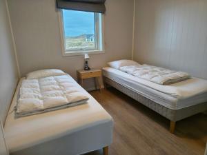 deux lits dans une chambre avec une fenêtre dans l'établissement 6 person holiday home in Dyrvik, à Dyrvik