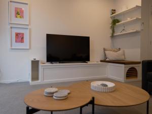 a living room with a tv and a coffee table at The Petone Beauty - Flash, Beachside in Lower Hutt