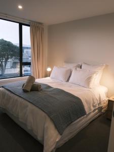 a bedroom with a large bed with a large window at The Petone Beauty - Flash, Beachside in Lower Hutt