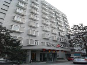 a large gray building with white balconies on it at Jinjiang Inn Shanghai Minsheng Road Metro Station in Shanghai