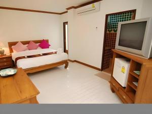 a living room with a bed and a television at Fah Place Hotel in Nan +44 photos