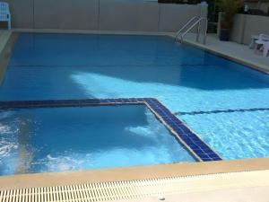 a large pool with blue water in a building at Hua Hin Avenue Hotel in Hua Hin