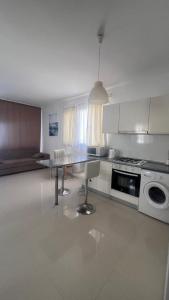 a white kitchen with a table and a stove at Caesar Resort Alexius in Bahçeler