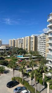 a parking lot with cars parked in front of a large building at Caesar Resort Alexius in Bahçeler