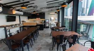 un restaurant avec des tables et des chaises dans une salle dans l'établissement Zoom Dharmahusada Hotel, à Surabaya