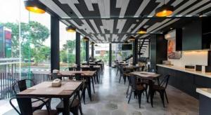 un restaurant avec des tables et des chaises dans une salle dans l'établissement Zoom Dharmahusada Hotel, à Surabaya