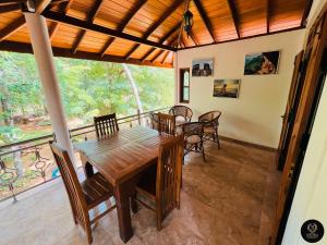 a dining room with a table and chairs and a balcony at Binara Home Stay in Polonnaruwa