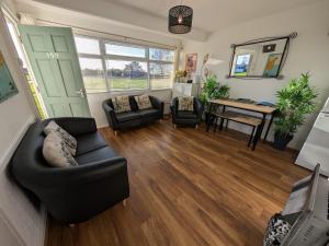 a living room with a couch and a table at 159, Two bed Chalet on Sunbeach Holiday Park - Sleeps 5, pet friendly - Onsite entertainment, SWIMMING PASSES INCLUDED - plus WiFi, bed linen and towels included - only 300m from the beach! in Scratby