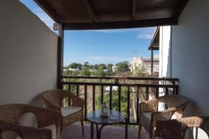 a balcony with a table and chairs and a large window at Proimos Maisonnettes in Plataniás