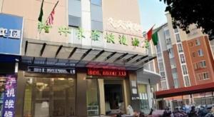 une façade d'un bâtiment arborant des drapeaux dans l'établissement GreenTree Inn Yangzhou East Passenger Station He Garden, à Yangzhou