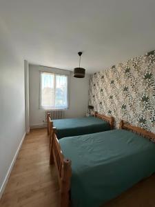 a bedroom with two beds and a window at Gite en Brocéliande avec vue in Néant-sur-Yvel +2 photos
