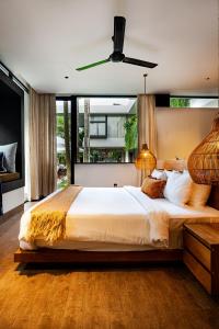 een slaapkamer met een groot bed met een plafondventilator bij Villa Zeno Arete Pererenan 6 Bedroom , Ice Bath, Sauna and Gym in Tumbak Bayuh +126 foto's