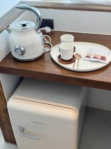 a tea kettle and a plate on top of a refrigerator at Pichcha Kohlarn in Ko Larn