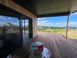 a room with a view of a wooden deck at Golden Ridge Retreat in Otorohanga