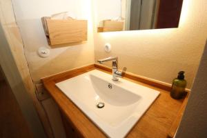 une salle de bains avec un lavabo blanc et un miroir dans l'établissement allio - das turmchalet, à Berching