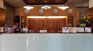 un comptoir avec des horloges sur le mur dans un magasin dans l'établissement Cactus Resort & Hotel, à Khon Kaen