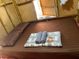 a bed in a small room with two towels on it at Khaosok August Freedom Camp in Khao Sok