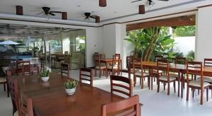 une salle à manger avec des tables et des chaises en bois dans l'établissement Ipil Suites Puerto Princesa, à Puerto Princesa