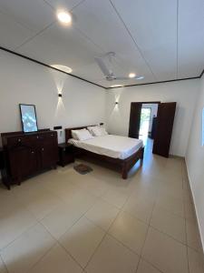 a bedroom with a bed and a dresser in it at MJ Villa Ahangama in Ahangama