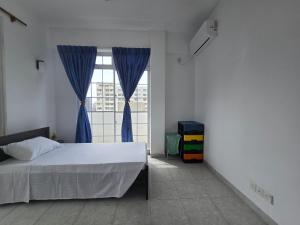 a bedroom with a bed and a large window at Beachfront City Escape Sunset Balcony AC WiFi in Colombo