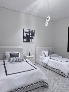 哈伊勒منتجع دارك的卧室设有2张床和白色的墙壁。