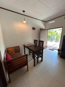 a dining room with a table and a bench at MJ Villa Ahangama in Ahangama