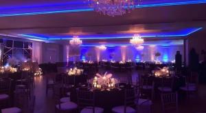 a room filled with tables and chairs with chandeliers at Hotel Saddleback in Norwalk