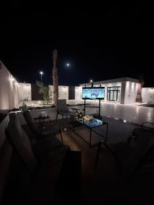 a living room at night with a large screen tv at منتجع دارك in Hail +4 photos