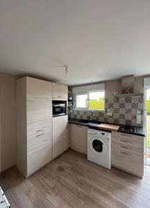 Una cocina con lavadora y secadora. en Nid Douillet, en Néant-sur-Yvel