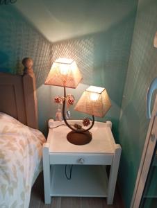 una mesa con dos lámparas junto a una cama en Nid Douillet, en Néant-sur-Yvel