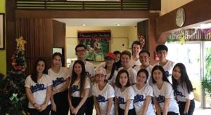 ファンにあるPhumanee Home Hotelのクリスマスツリー前の絵を描く集団