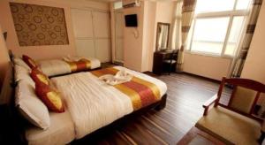 a hotel room with two beds and a television at De Hotel Veda in Kathmandu