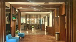 Un vestíbulo con sillas azules en un edificio. en Indies Style Hotel Bandung, en Bandung