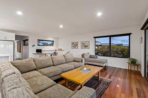 una sala de estar con un sofá y una mesa en Idyllic Aireys Retreat - where ocean & hills meet, en Aireys Inlet